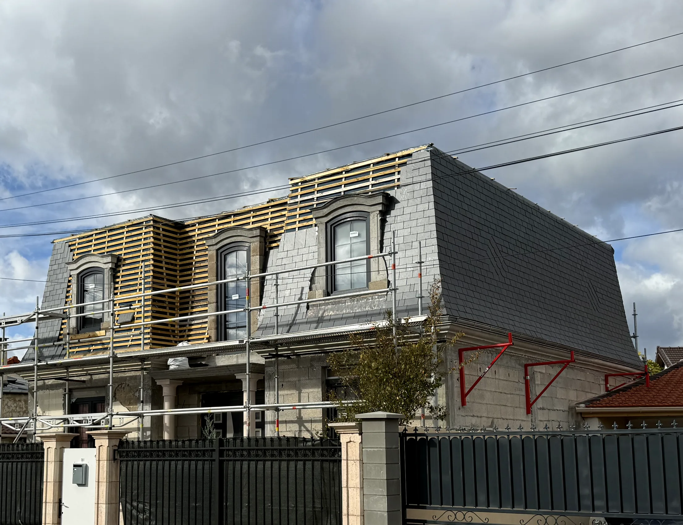 Toiture mansardée en ardoise en cours de réfection, lucarnes reprises une à une — chantier Will Couvreur
