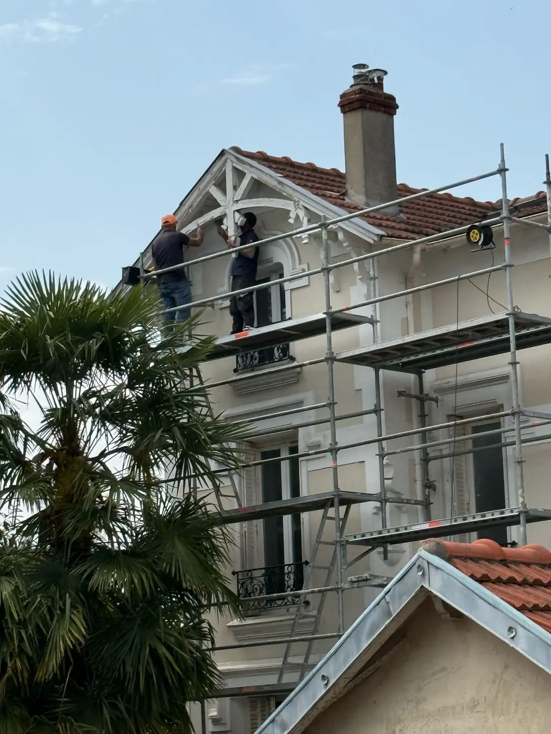 Échafaudage de pied monté sur rue devant un immeuble, pour des travaux de toiture et de façade