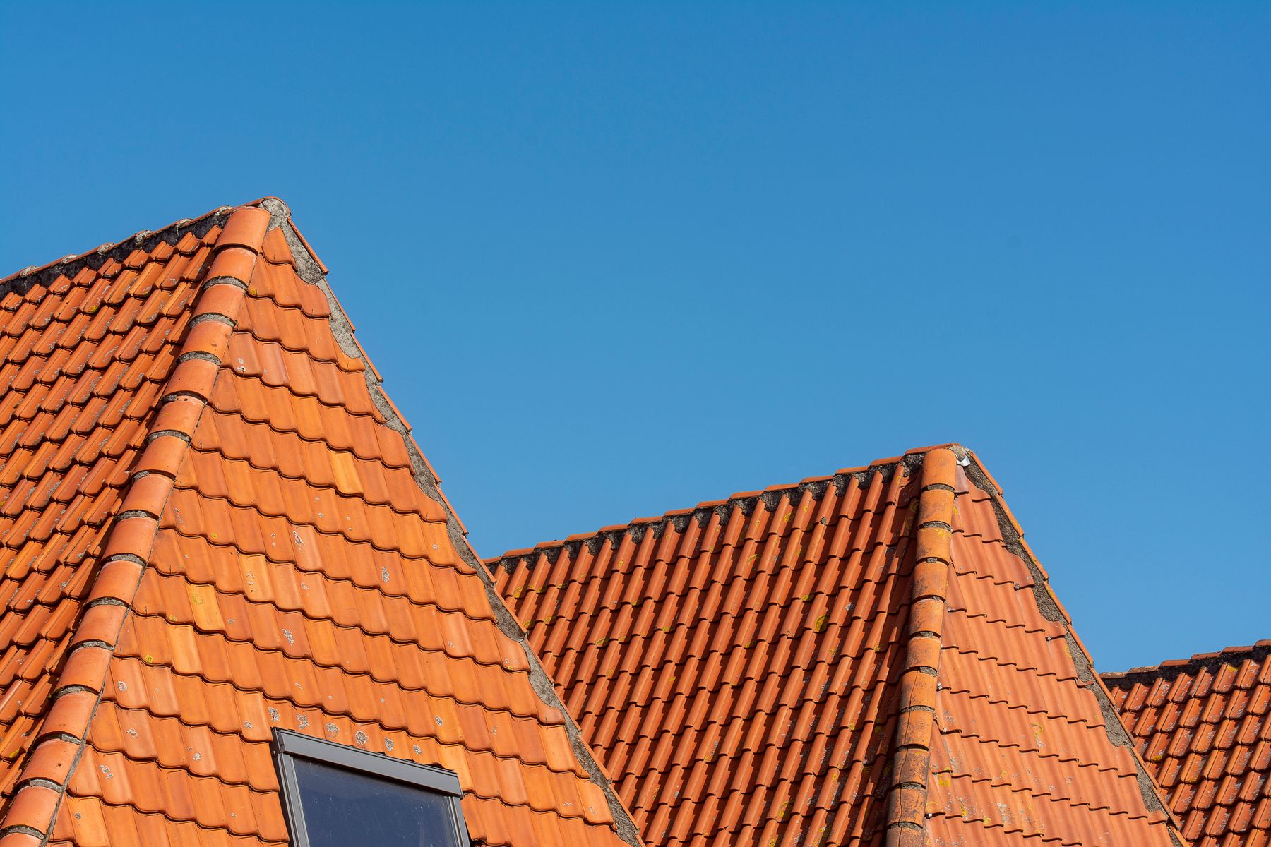 Détail d’une toiture en tuiles et de sa zinguerie